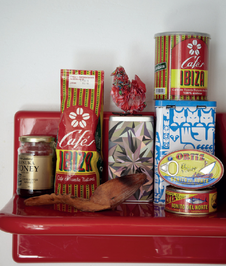 A glossy red kitchen shelf holds a selection of eye-catching cans and packages - photo 16