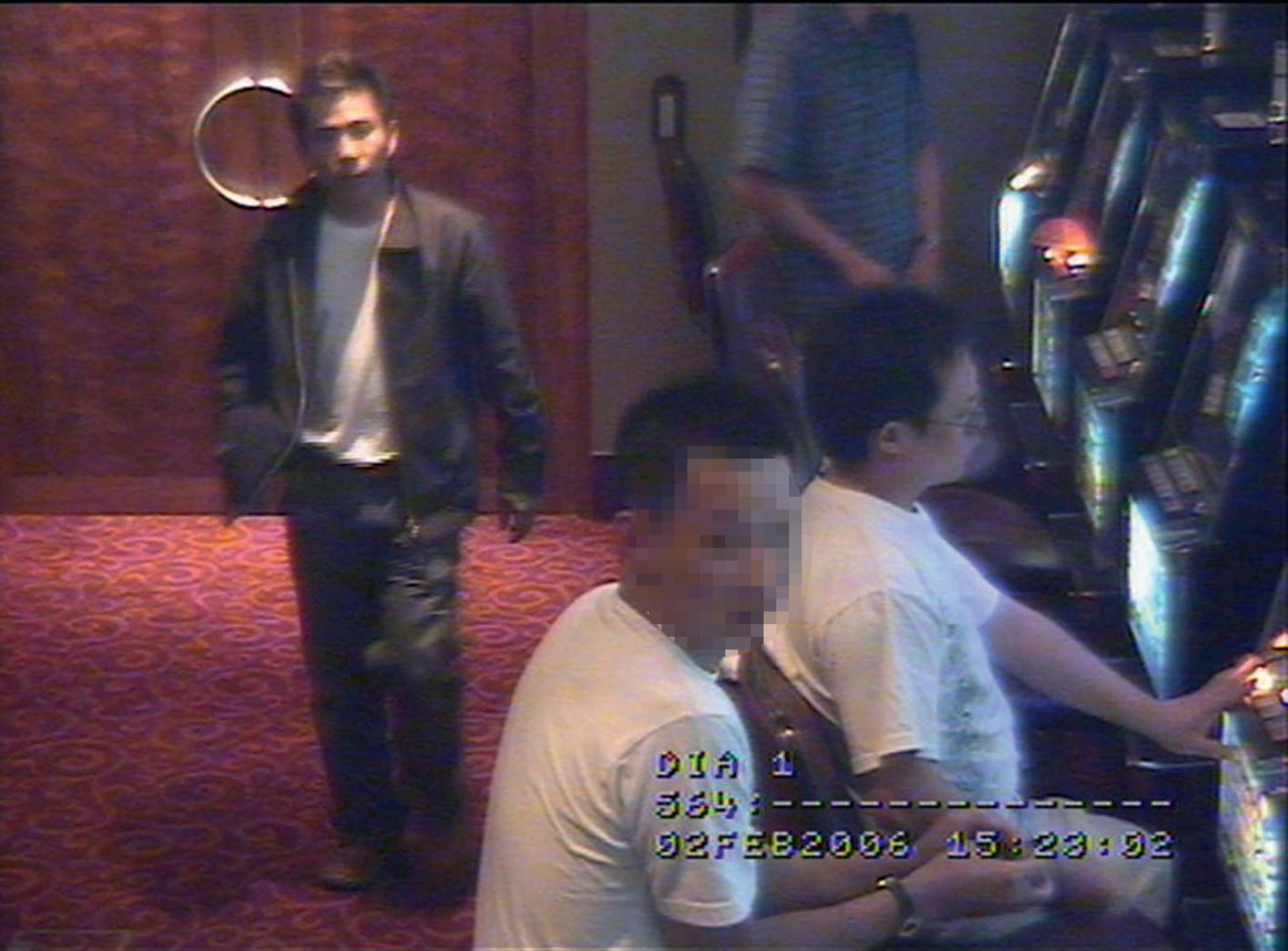 Zhou Ri Tong seated at pokie machine and Tac Kin Voong wearing jacket - photo 5