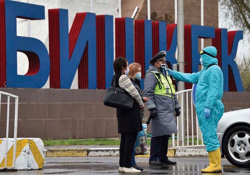 A medic checks peoples temperatures at a checkpoint outside Bishkek the - photo 5