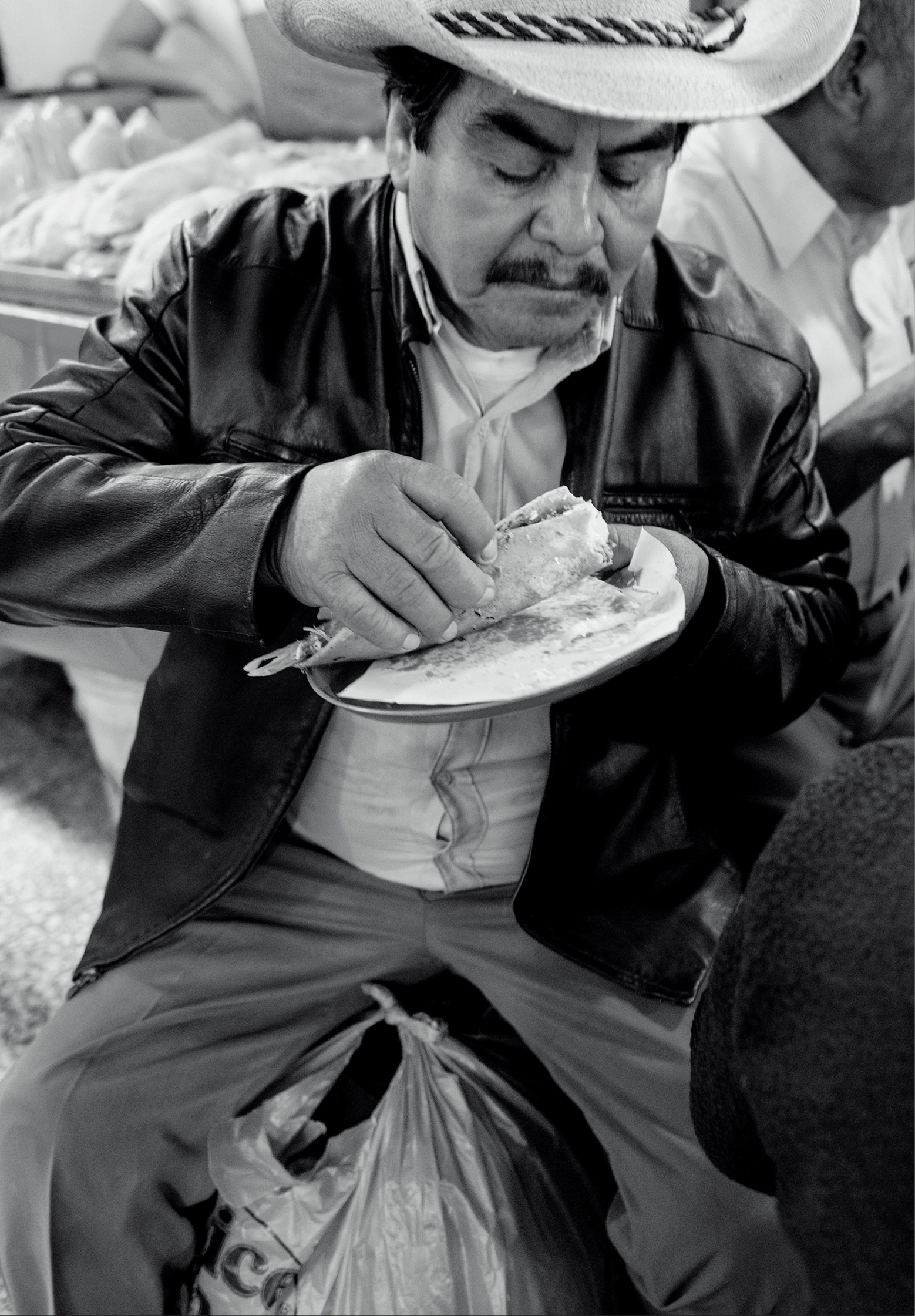 A customer enjoys a taco in La Merced Market Colorful heirloom corn that will - photo 1