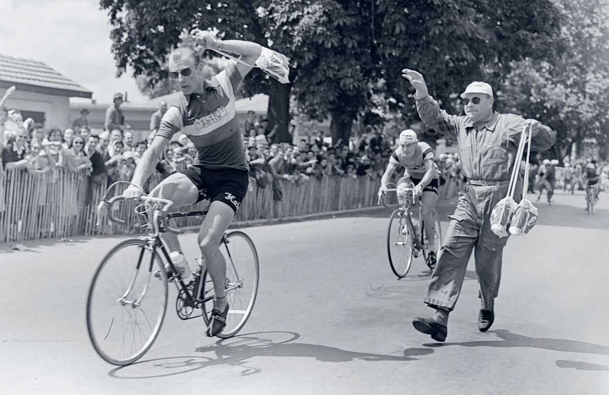 French cyclist Andre Darrigade grabs a musette at high speed during the 1956 - photo 4