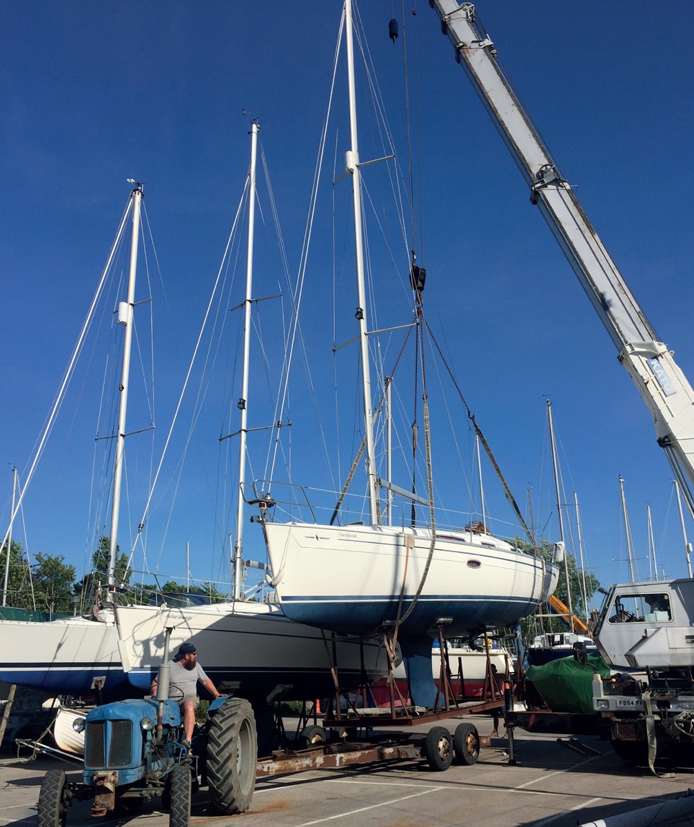 Lowering a fin-keeled yacht and cradle onto a trailer at the beginning of a - photo 5