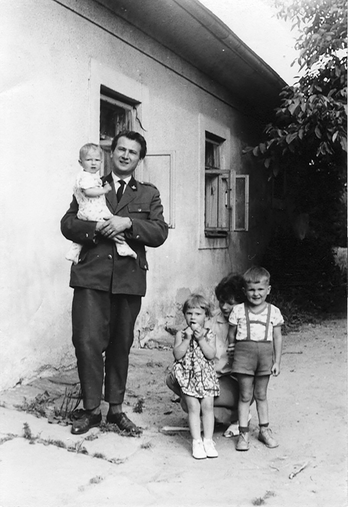 Nestled in my fathers arms I pose with my family in front of our home a few - photo 2