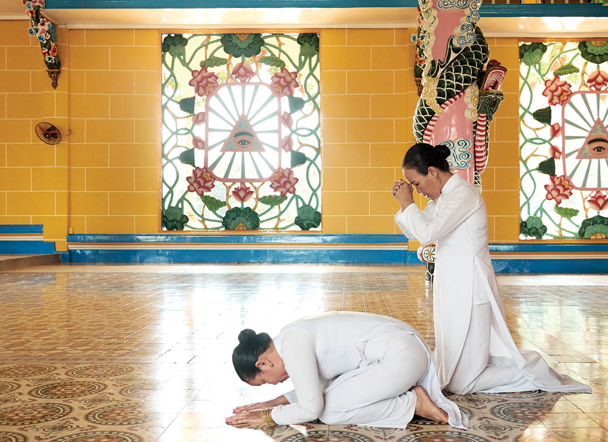 Two Cao i sisters praying with the Divine Eye in the background A Buddhist - photo 4