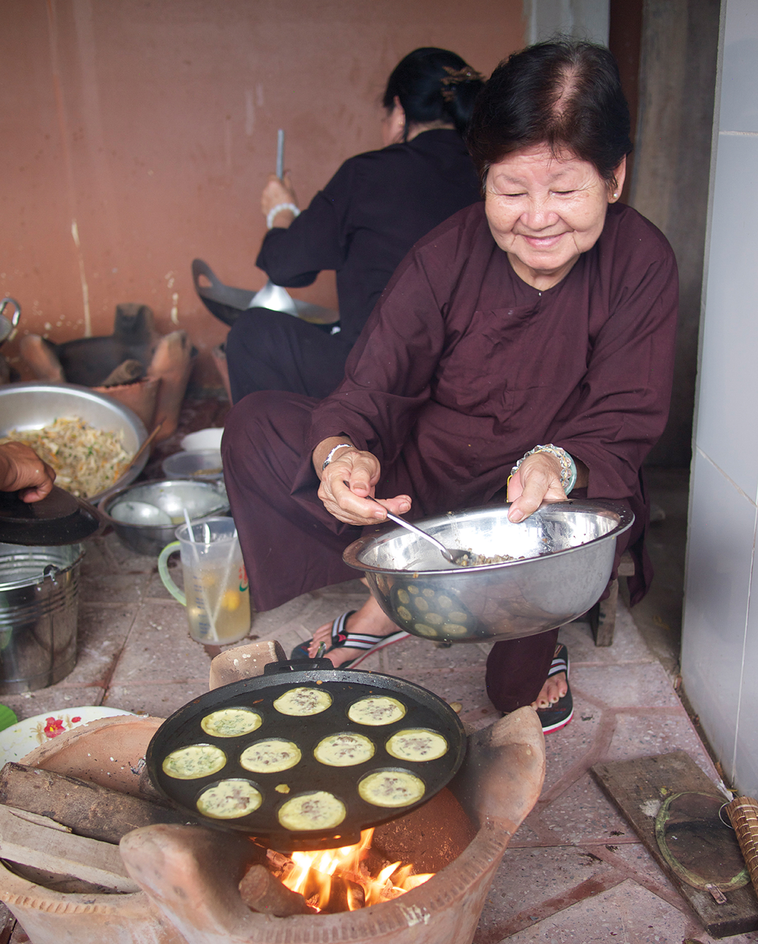 A Buddhist lay believer cooks bnh kht a mini rice pancake filled with lentils - photo 5