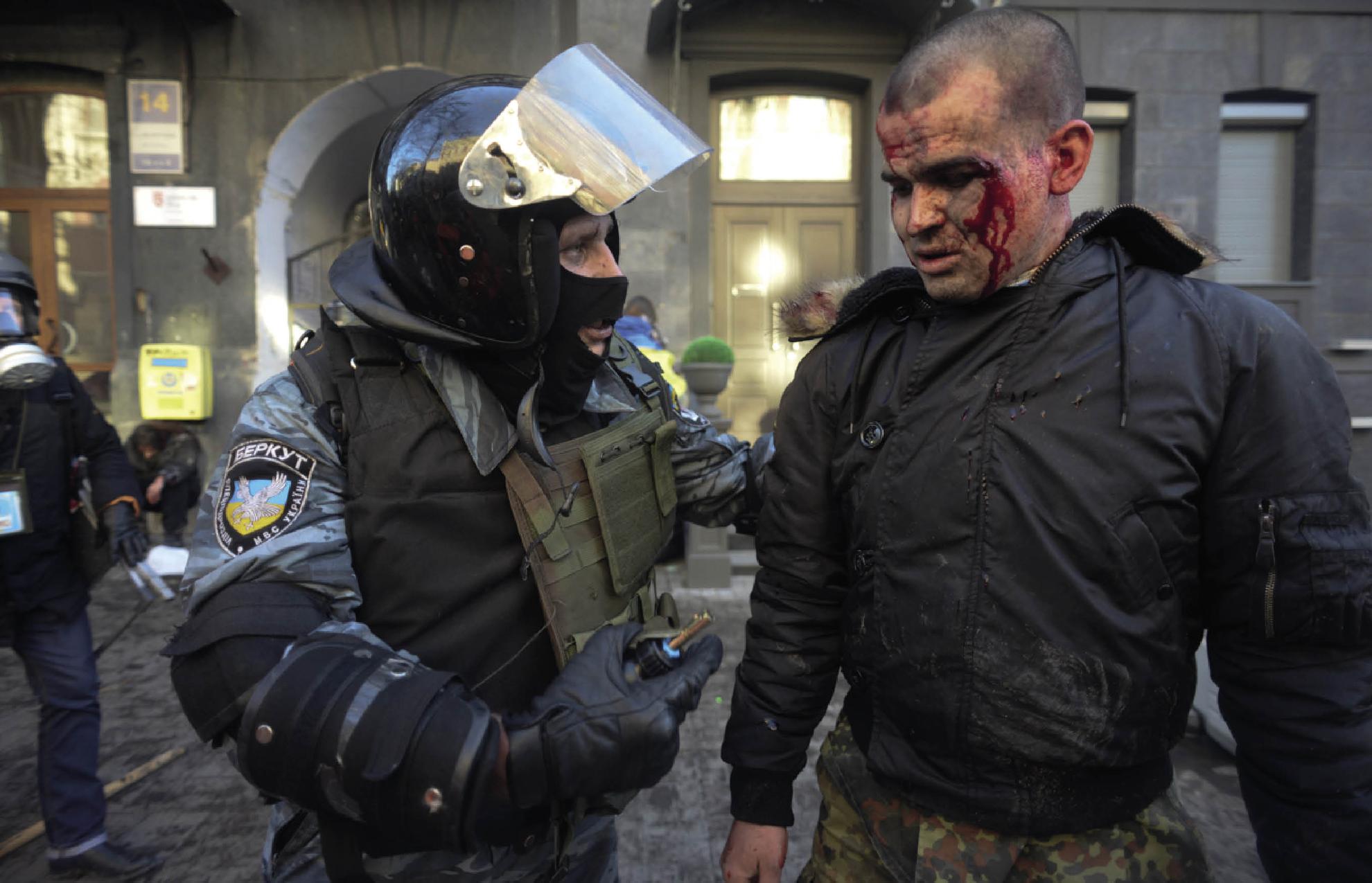 A Berkut riot policeman left with a bloodied protester during the February - photo 4