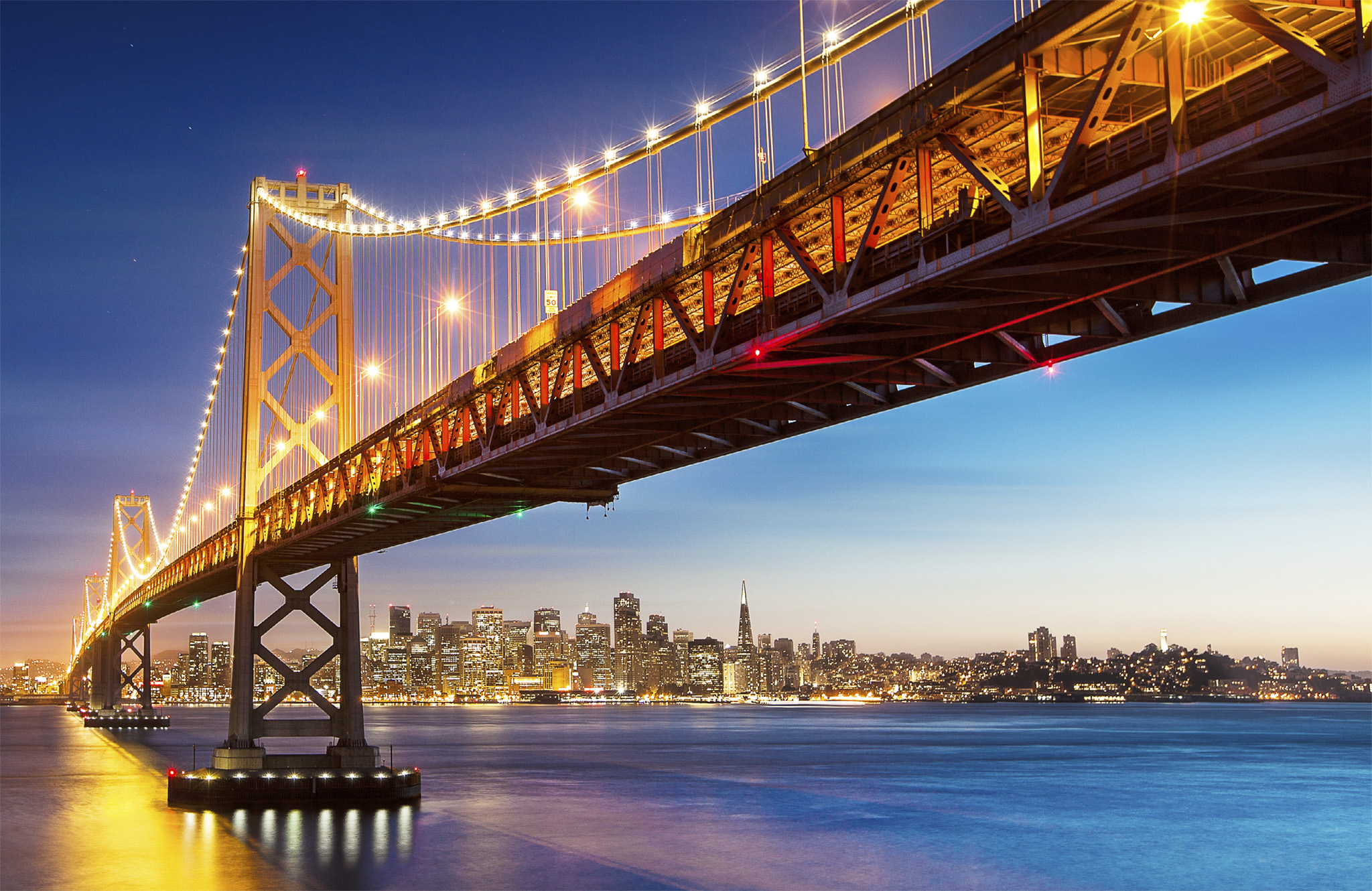 t The Oakland Bay Bridge lit up at dusk as it stretches across to San - photo 5