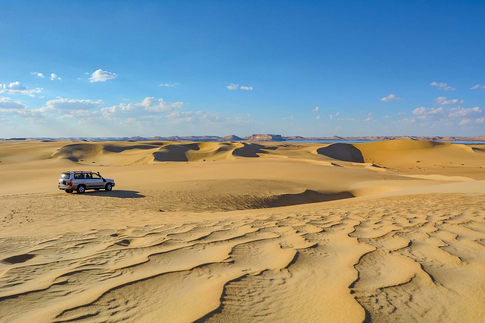 Hold on tight as your local guide speeds along Siwas undulating dunes in an - photo 20