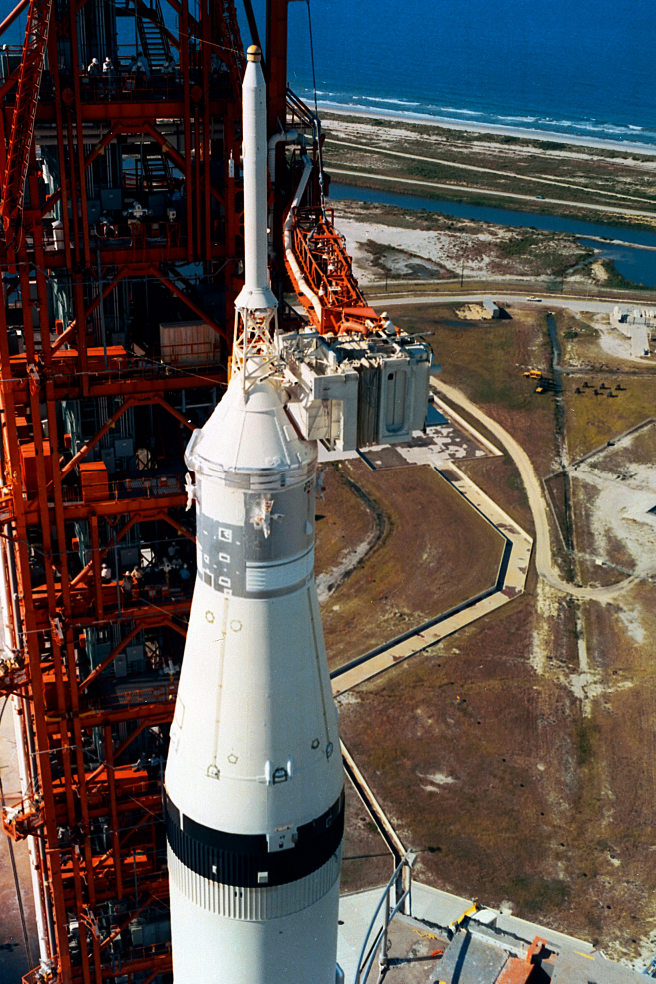 A technician works atop the white room perched beside the top of the Saturn V - photo 10