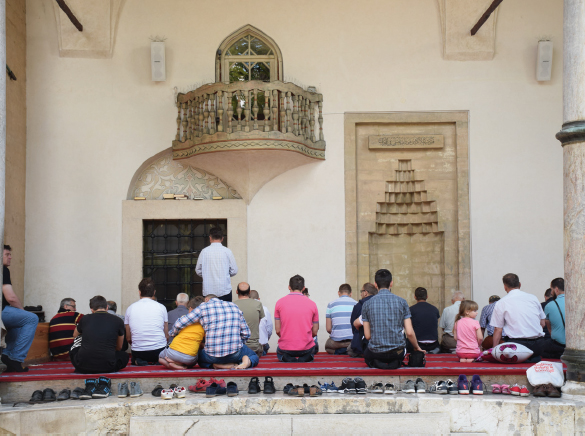 Worshippers sit in front of the travellers mihrab beneath the portico of - photo 6