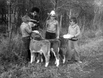 My mom my brother and sister and me in the cowboy hat bottle-feeding - photo 2