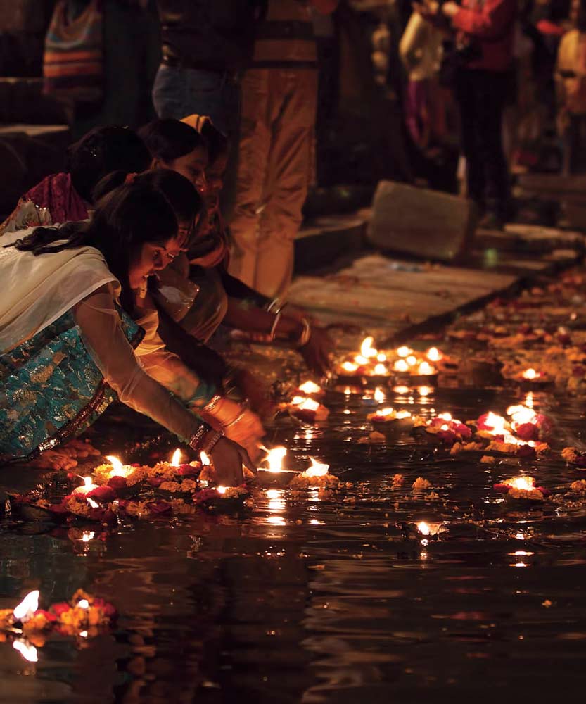 Diyas or oil lamps are put on small boats made of leaves and set afloat on - photo 6