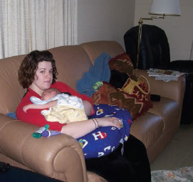 Me as a new mom with Rylee asleep on me in my grandparents living room in - photo 11