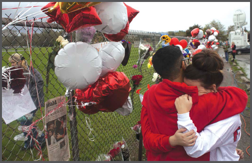 Community members grieve by a memorial for the victims of a high school - photo 2