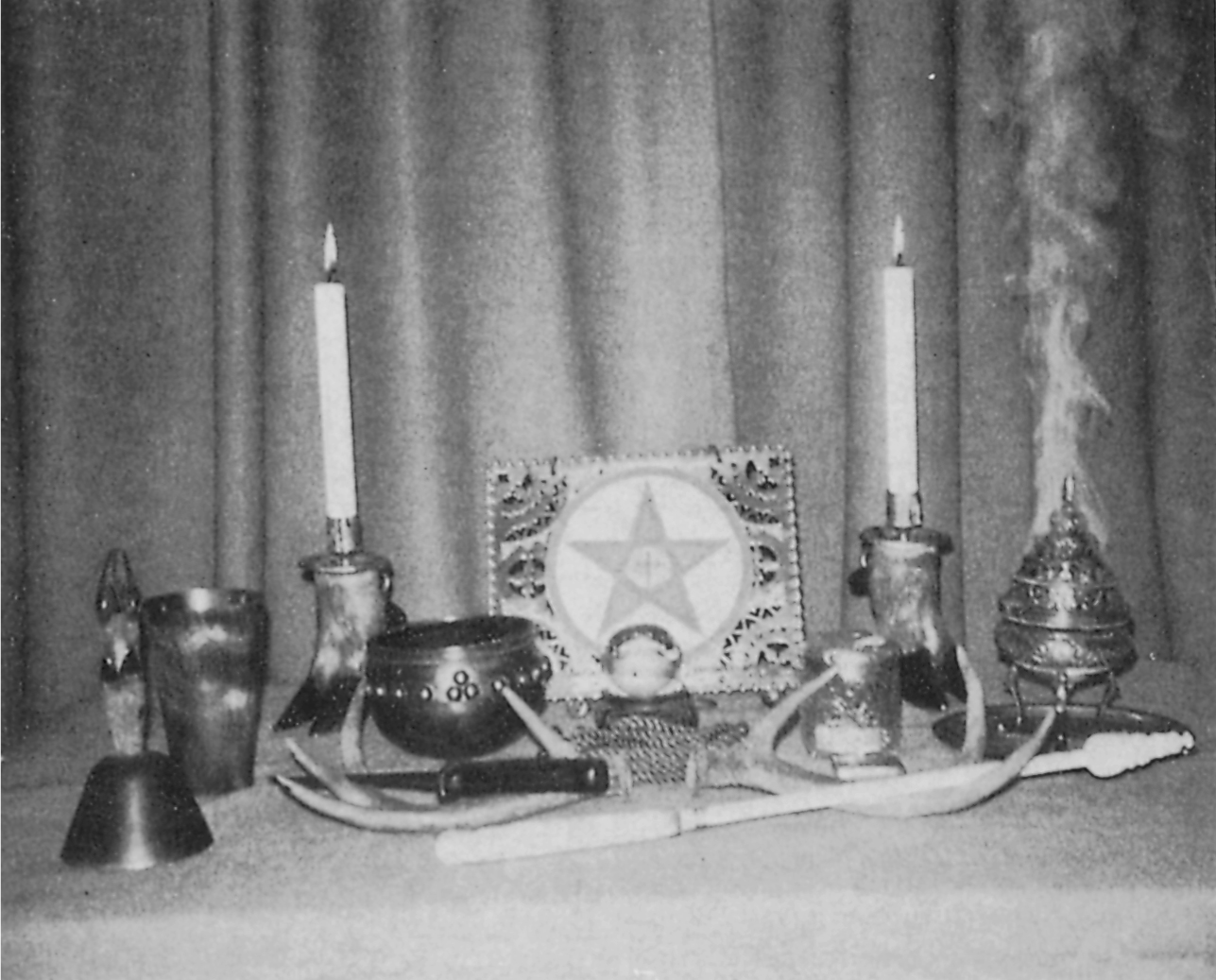 Witchcraft implements displayed on an altar two cloven-hoof candlesticks the - photo 8