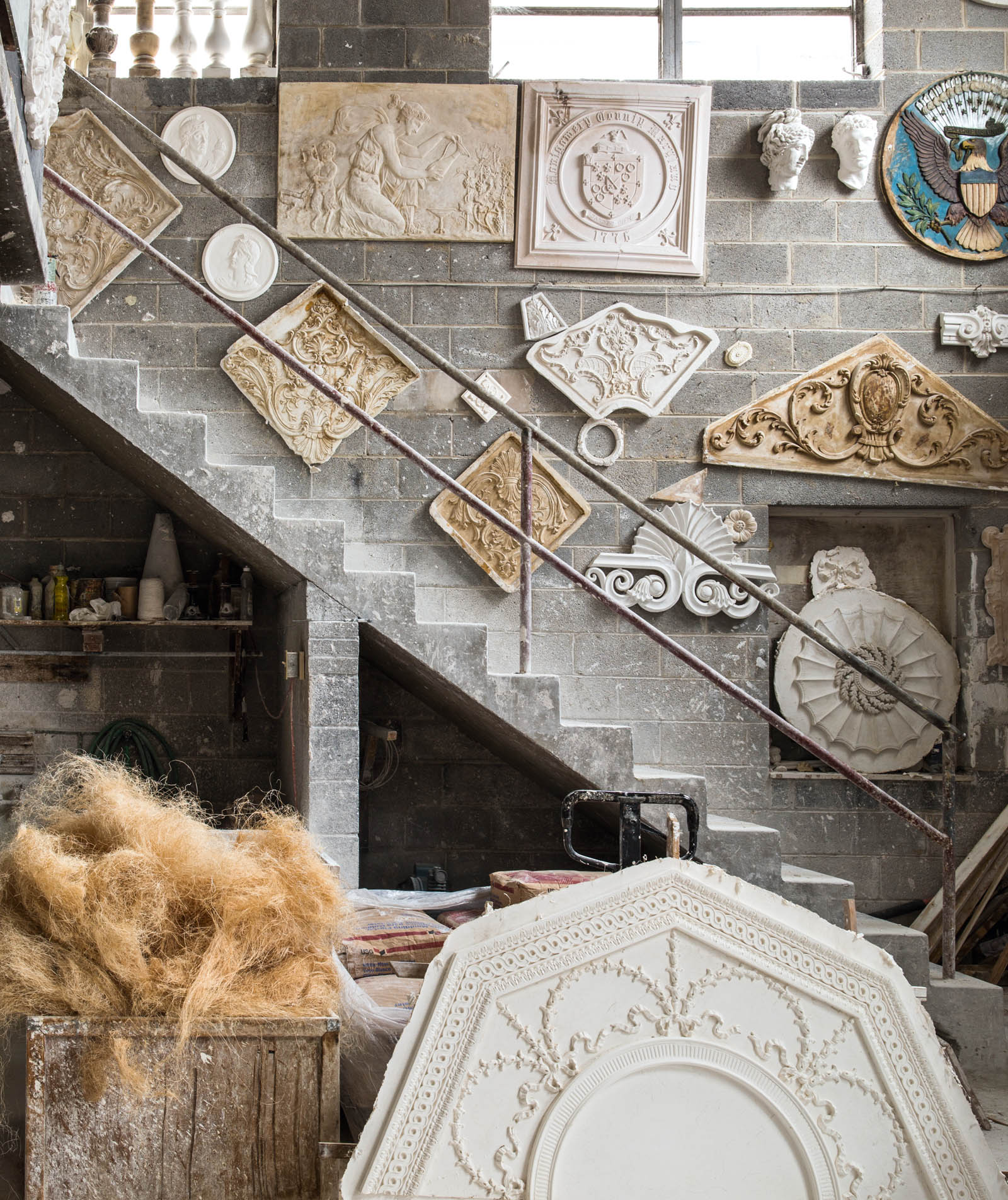 A collection of decorative plaster plaques heads and medallions hang ona - photo 9