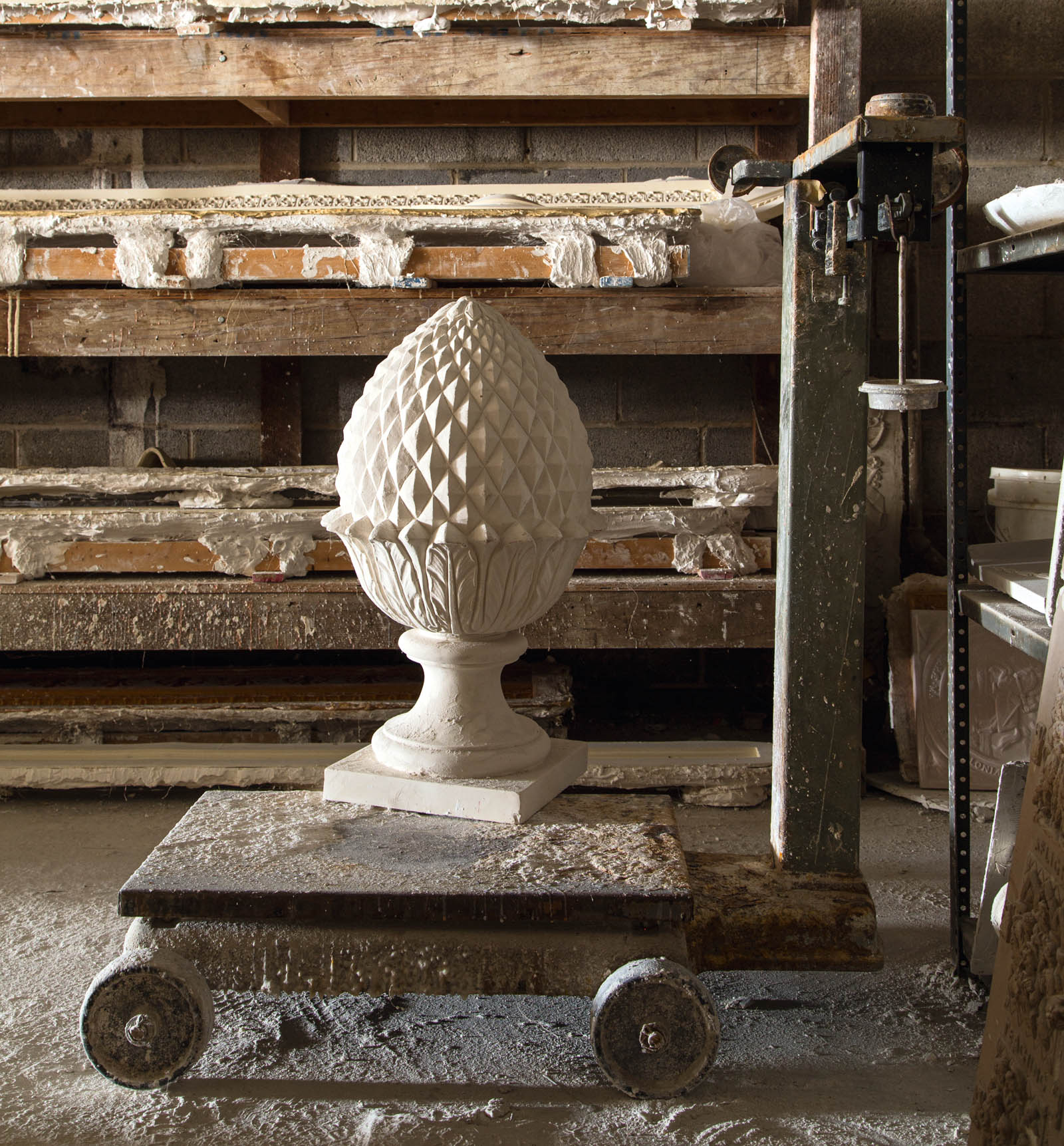 A beautifully detailed plaster pineapple sits on top of an industriallift at - photo 10