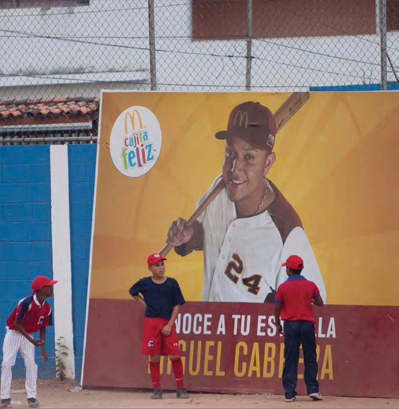 Young baseball players stand in front of an advertisement featuring Cabrera He - photo 4