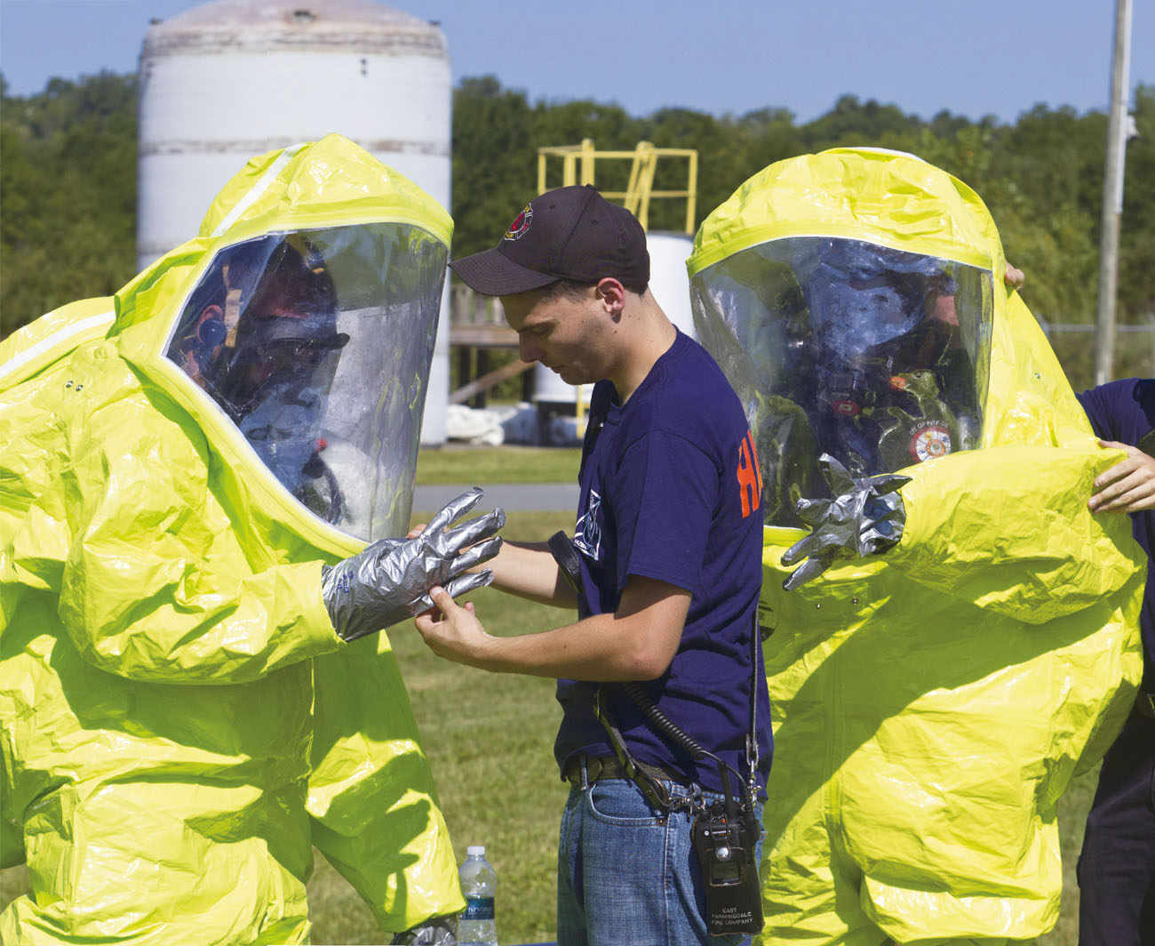 Hazmat workers have help getting into their PPE to ensure that the suits are - photo 5