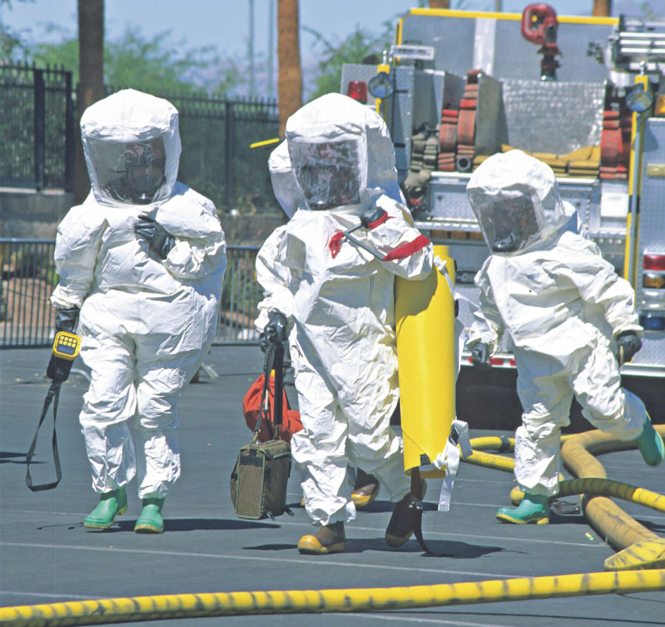 Hazmat workers approach a scene in full PPE gear carrying the tools they need - photo 8