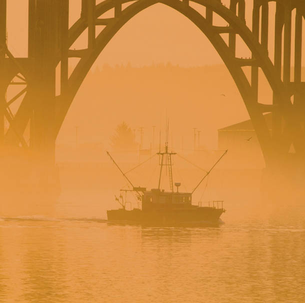 Fishing boat heading out at sunrise on a foggy morning under Yaquina Bay - photo 7