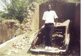 My brother Aimable stands in the wreckage of Dads burned-out car Me bottom - photo 24