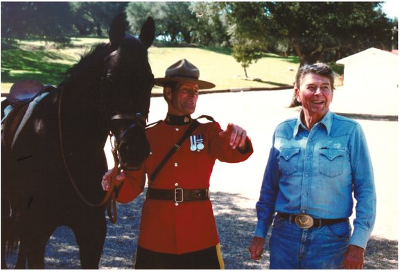 A member of the Royal Canadian Mounted Police presents President Reagan with a - photo 11