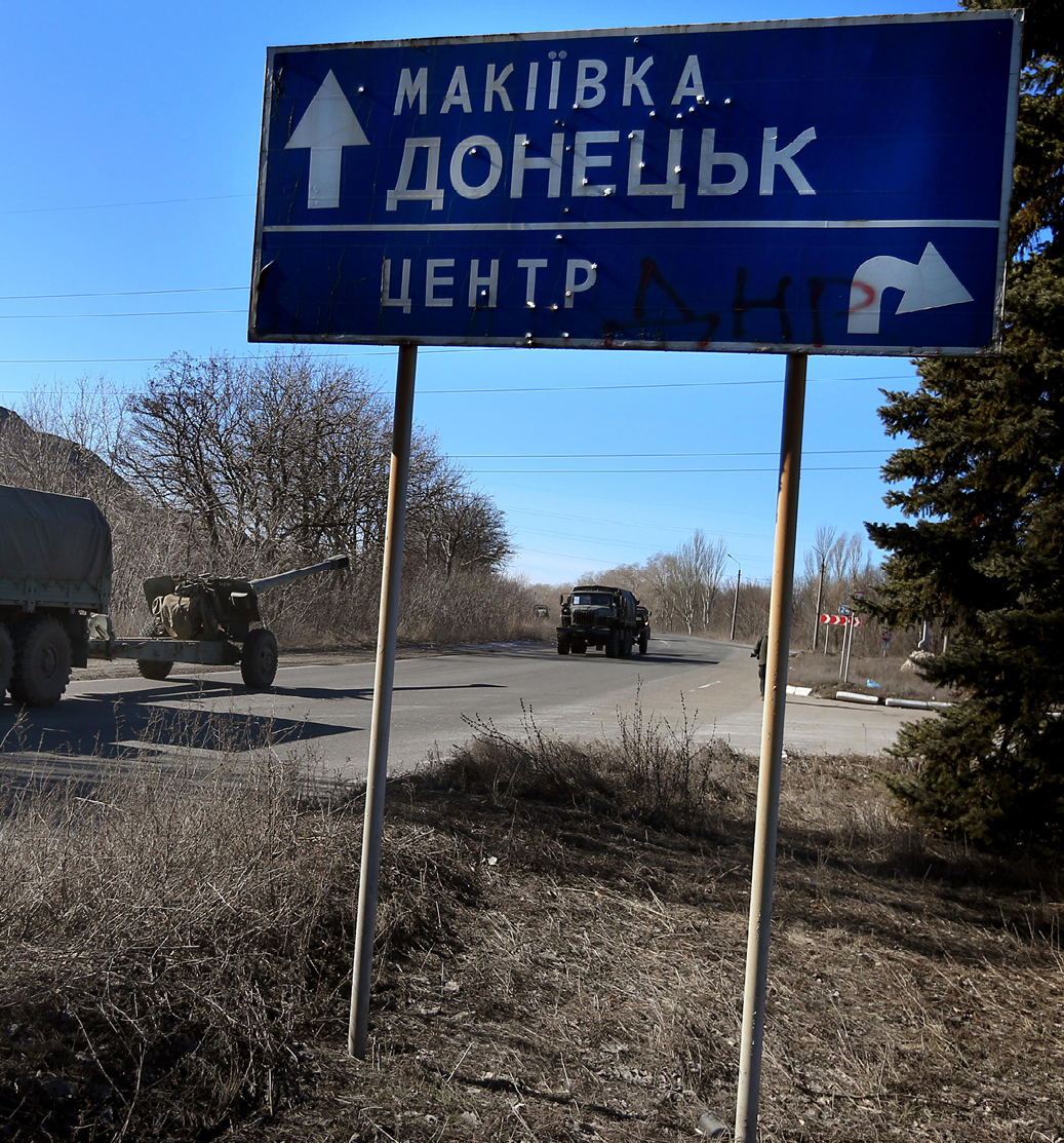 Road signs for Makivka and Donetsk with Msta-B 152 mm howitzers on the road - photo 8