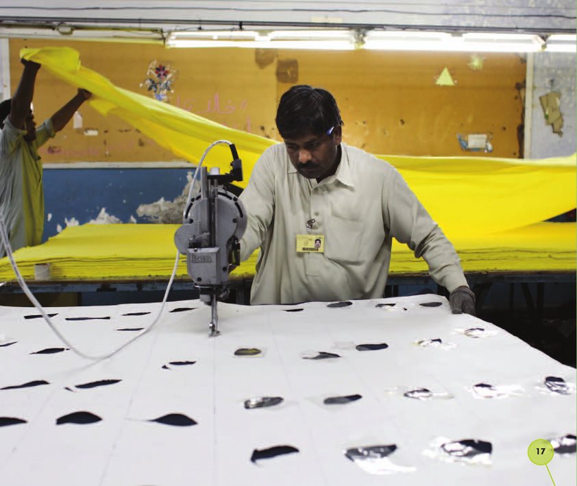 A worker sews the cloth A worker uses a sewing machine to sew the pieces - photo 17