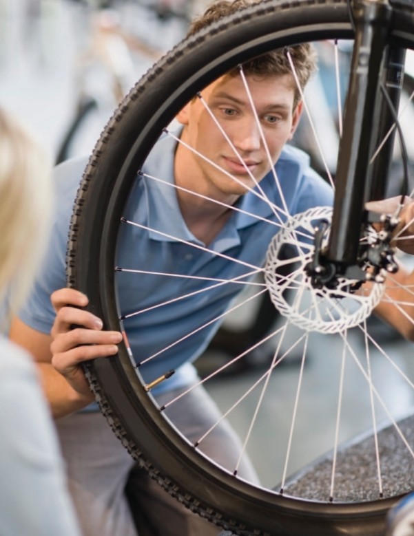 A young man examines a bicycle wheel on the job Being handy can be a - photo 3