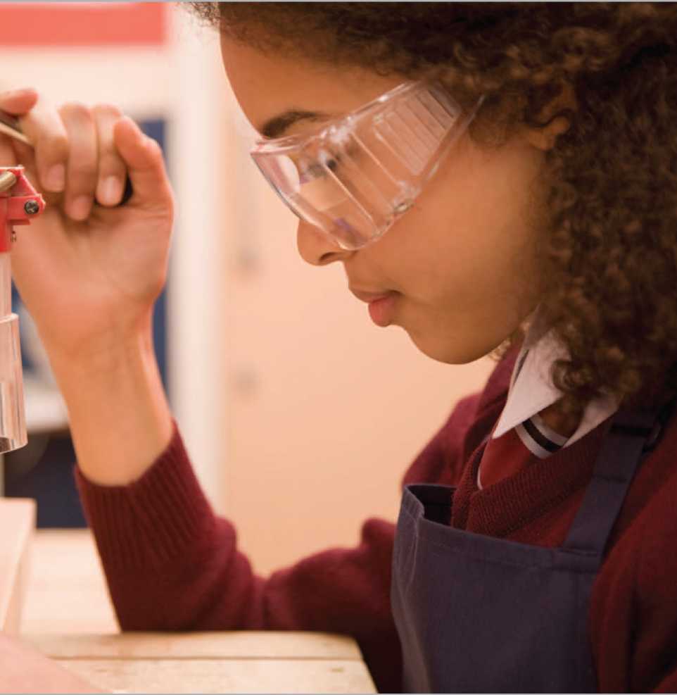 A teenager drills a piece of wood in a shop class Many young people first - photo 5