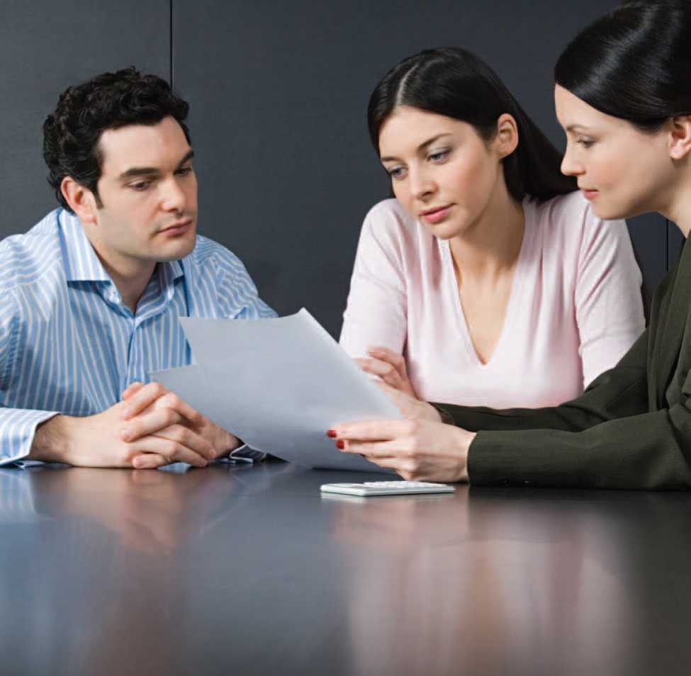 This couple discusses the terms of a mortgage with a banks loan officer - photo 4