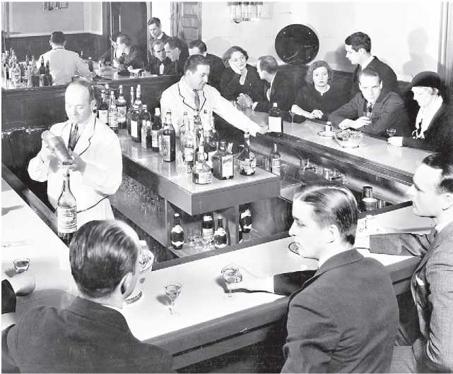 Uniformed bartenders serve alcohol to customers in a New York City speakeasy in - photo 5