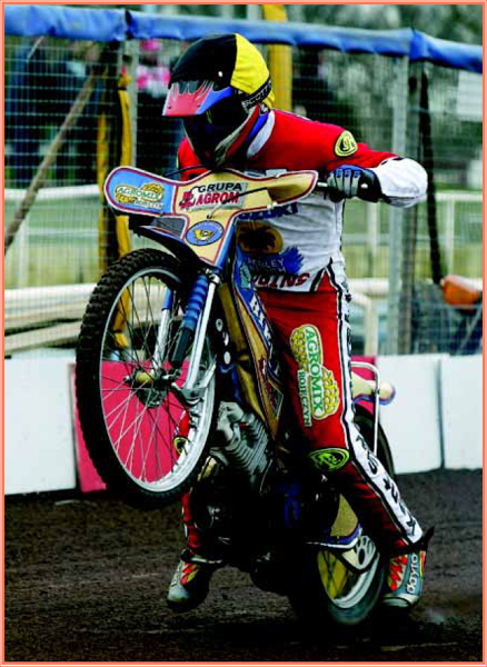 A rider pulls a wheelie as he rockets out of the gate and lean into the - photo 3