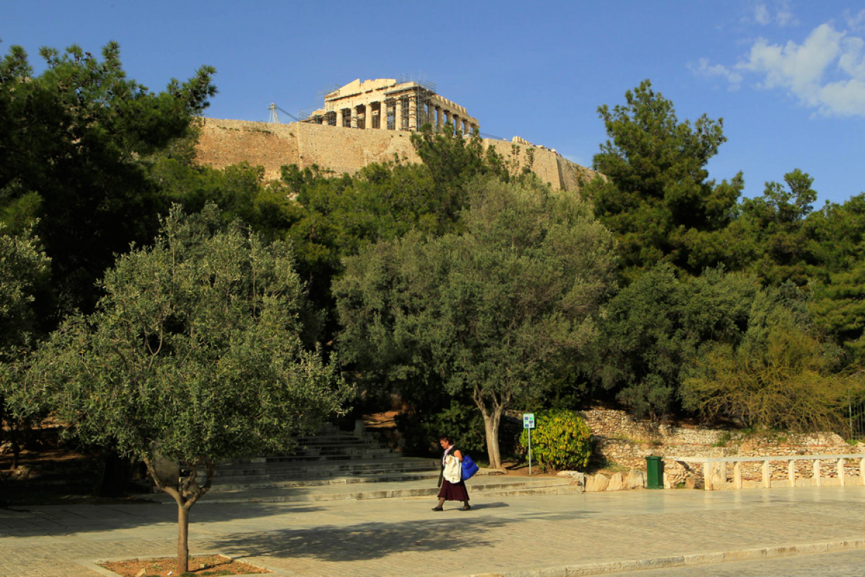 An embroidery merchant passes Athens Parthenon which has stood for more than - photo 4