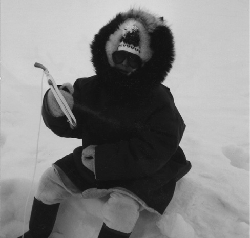 Using a traditional fishing rod a young Jordin enjoys ice fishing at home near - photo 2