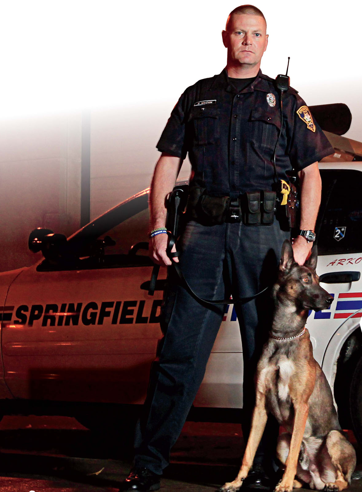 A Belgian Malinois remains alert beside his handlerA police officer and his or - photo 7