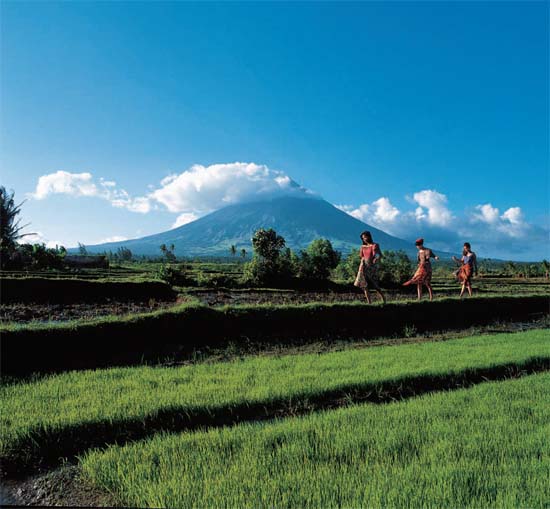 Cloud-capped Mayon Volcano looms in the far background as country lasses - photo 3