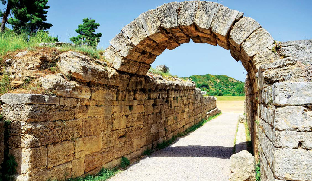 A tunnel-like entrance built with stone leads to the track in an early Greek - photo 8