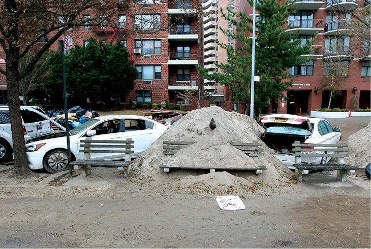 Two weeks after Sandy hit the New York region sand piles and damaged vehicles - photo 3