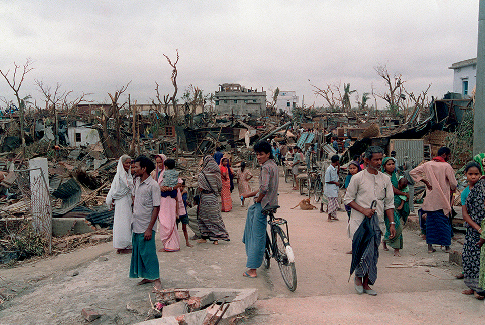 People in Bangladesh walk near ruins in April 1989 after a deadly tornado - photo 4