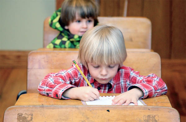 Children sit at antique school desks in the Original Santa Claus Post Office - photo 10