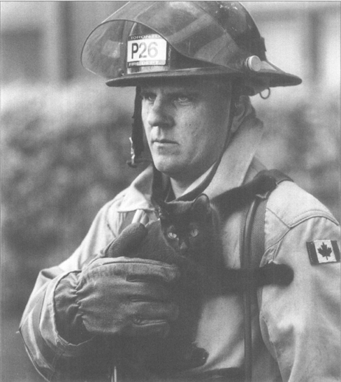 Dave Albright holds a cat rescued from a fire in a fifth-floor apartment Even - photo 2