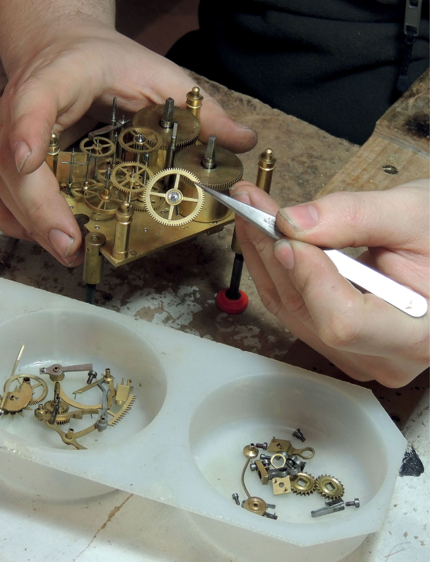 A striking carriage clock being disassembled for cleaning The components are - photo 2