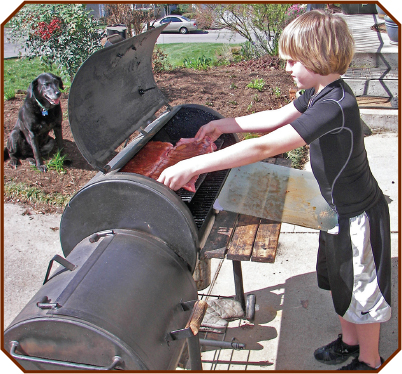 My then-seven-year-old son Trevor loading spareribs into the first smoker I - photo 3