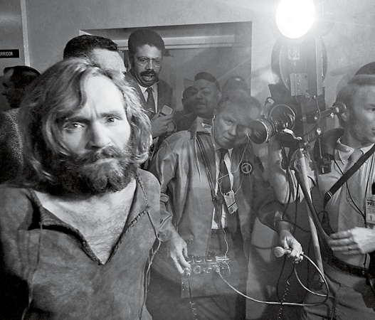 CAUGHT IN THE GLARE Cameramen filmed the scene as Charles Manson was brought - photo 3