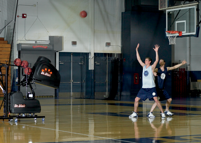 A basketball shooting machine lobs a shot toward the basket during a defensive - photo 6