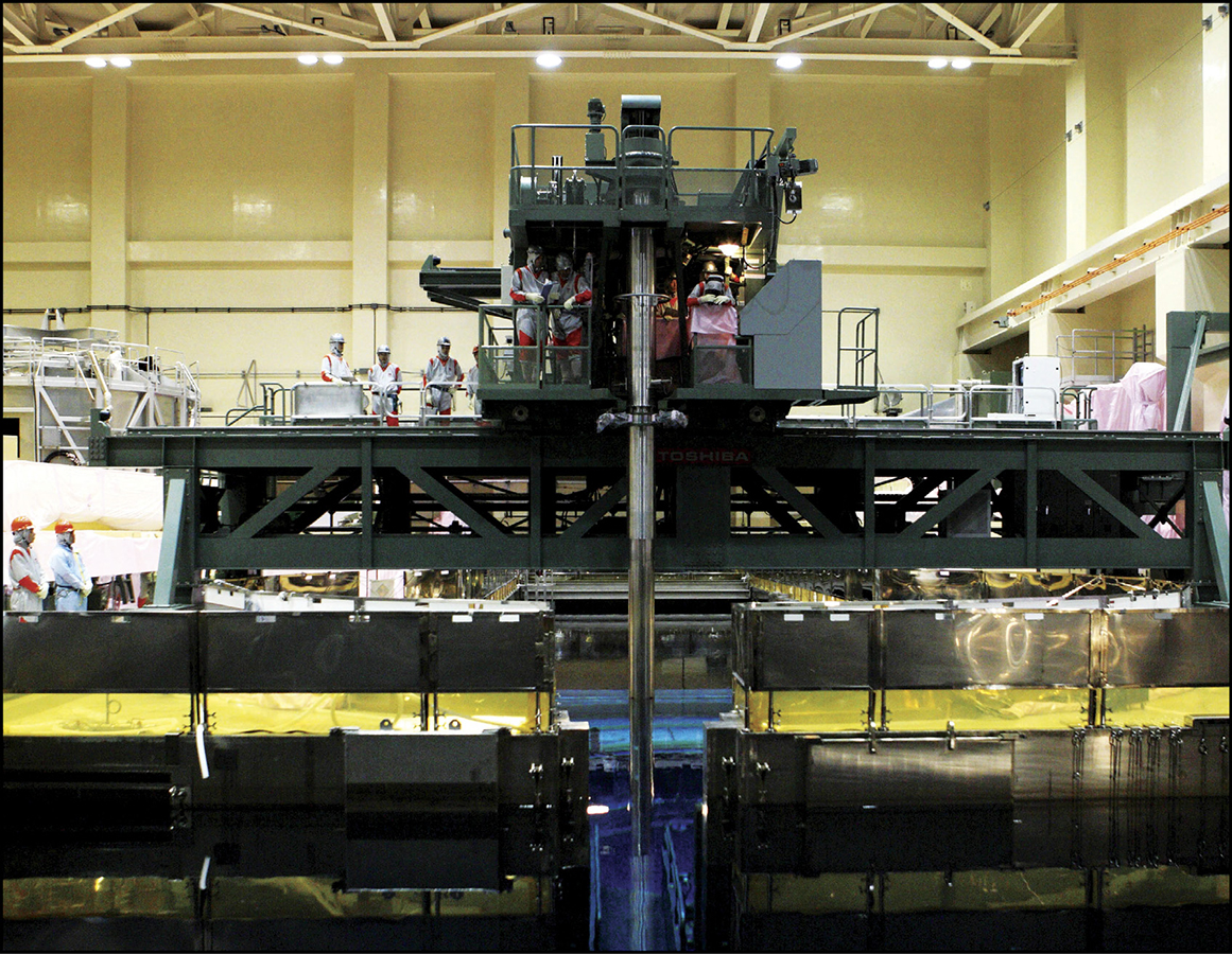 Employees at Fukushima Dai-Ichi oversee the process of loading fuel into - photo 5