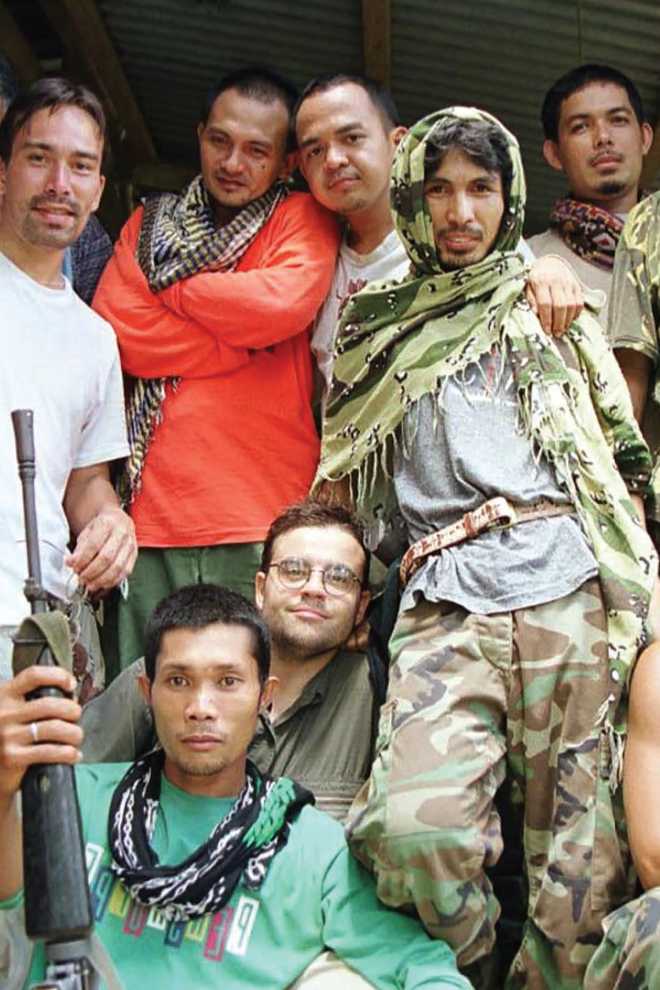 Opposite Abu Sayyaf fighters pose with journalists in May 2000 in their camp - photo 3