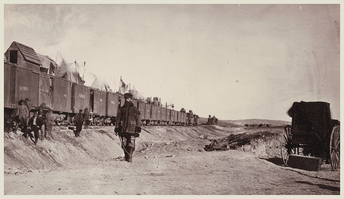 Railroad foreman Jack Casement walks by Russells field darkroom wagon near the - photo 5